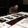 Tony Levin signing trial proofs of a vintage portrait he made Peter Gabriel, circa 1983