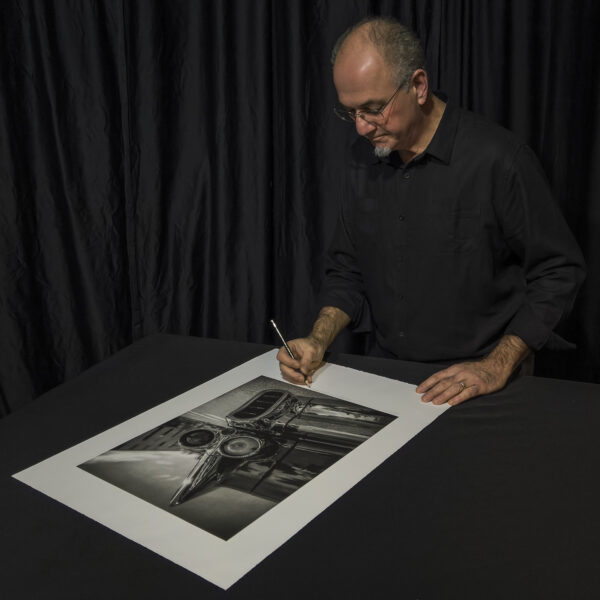 Jerry LoFaro signing his polymer photogravure print "Panic on Main Street" (2022).