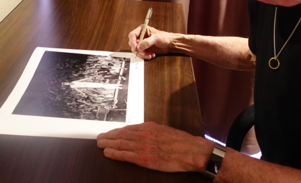 Tony Levin signing his print "Lay Your Hands on Me, 1983", featuring Peter Gabriel.