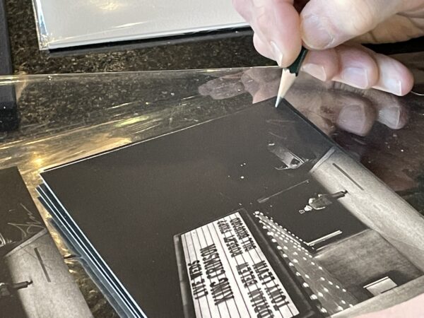 Tony Levin signing small photogravure print of his photo "Perkins Palace Marquee, 1981"